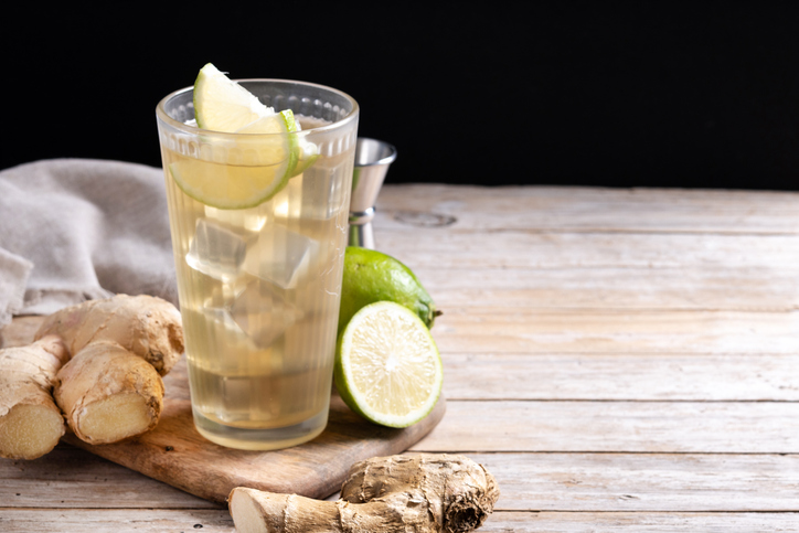 Fresh ginger ale drink in tall glass on wooden table
