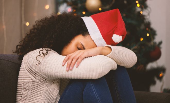 Shot of a young woman looking sad during Christmas at home