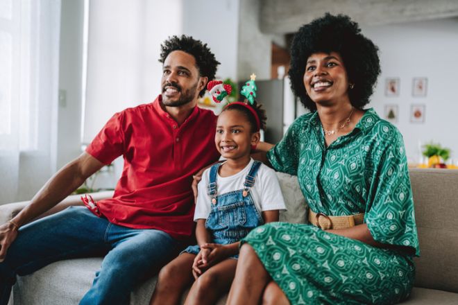 Family Sitting on the Sofa and Smiling During Christmas Season