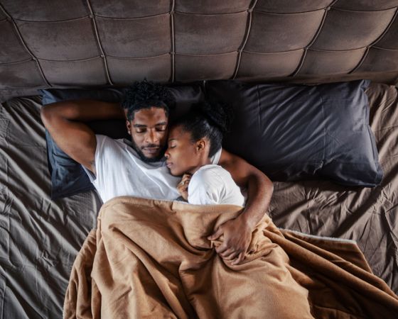 African american couple sleeping embracing in bed