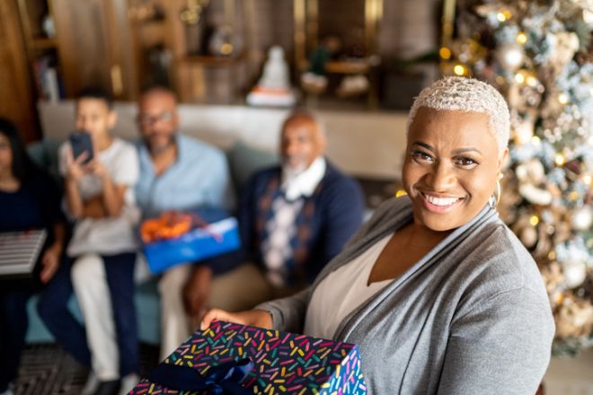 Portrait of a mature woman holding a Christmas present at home