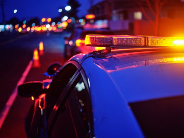 Police Car Stopped on a Road at Night with Emergency Lights
