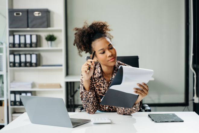 Young Asian businesswoman working with working notepad, tablet and laptop documents talking on the smartphone, tablet and laptop video call tax