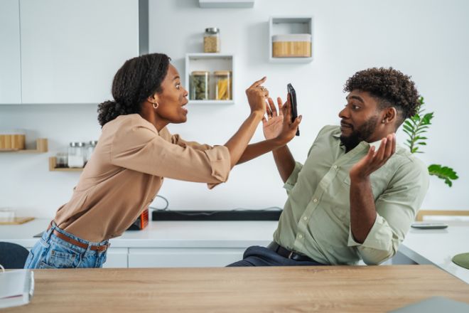 Couple having conflict over phone at home