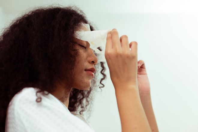 Young adult caucasian and African American women apply cosmetic moisture skin face sheet mask to treatment facial together. LGBT couples feel emotion fun happy to skincare relax together, copy space