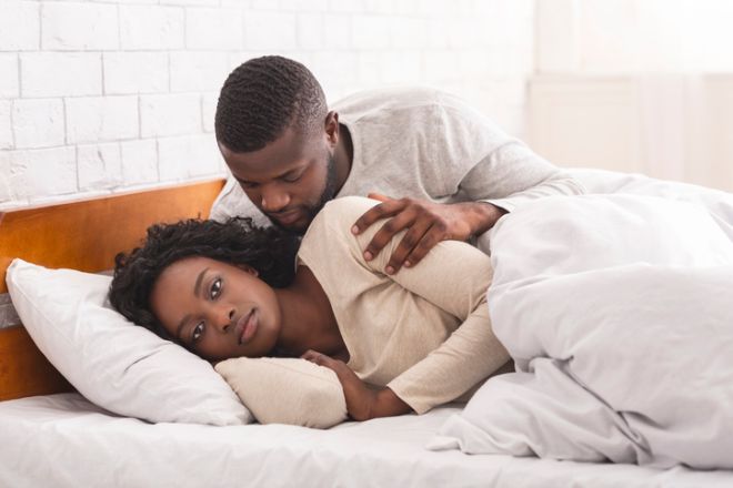 Woman ignoring husband in bed, refusing to make sex together.