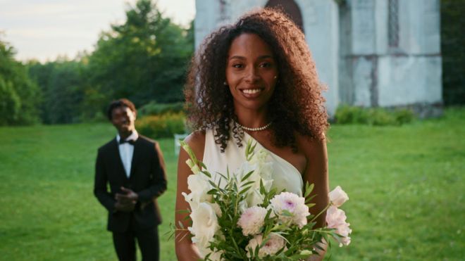 The bride smiles looking at the camera standing - Portrait.