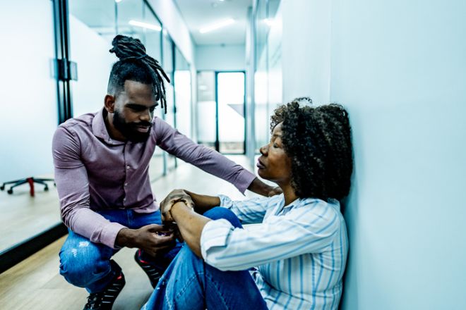 Worried businesswoman being comforted by coworker at office