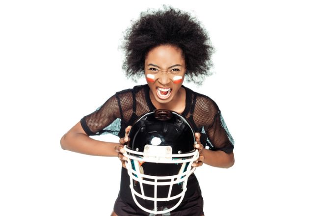 angry shouting female american football player with helmet in hands isolated on white