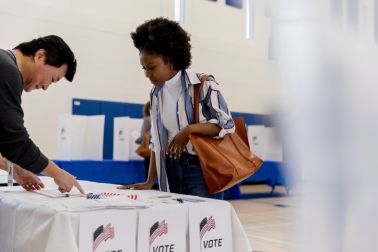 Voter casting ballot during election at polling station, people participating in democracy