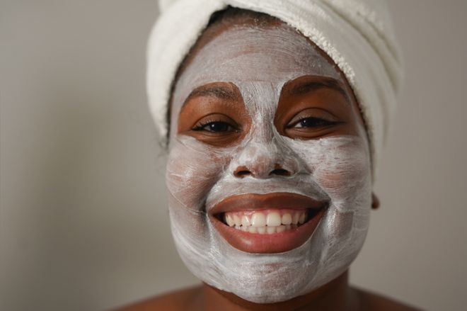 Young african woman applying face mask - Natural skin care routine - Cleaning face with natural cosmetics