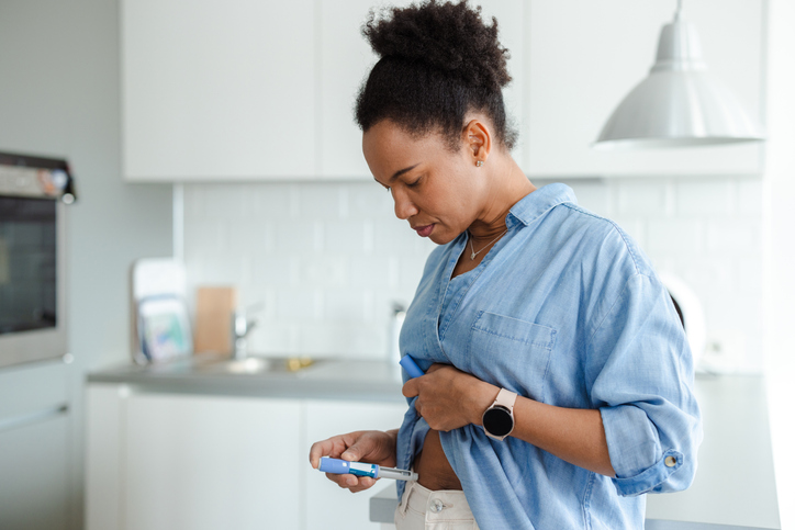 Woman administering medication in a brightly lit modern kitchen