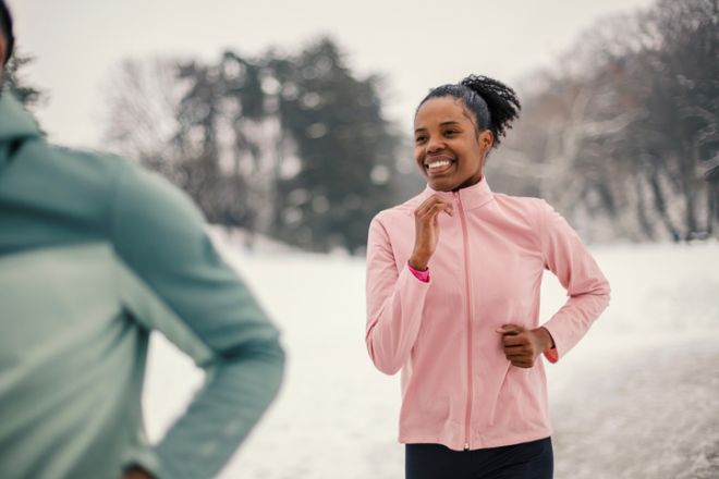 Young african american woman jogging winter park