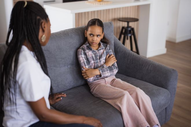 Angry teenage girl listening to her mother giving her lecture