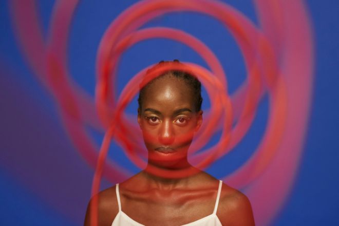 Confident young woman behind spiral red wire