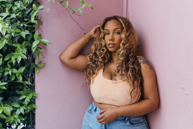 Empowered Woman Standing by Pink Wall