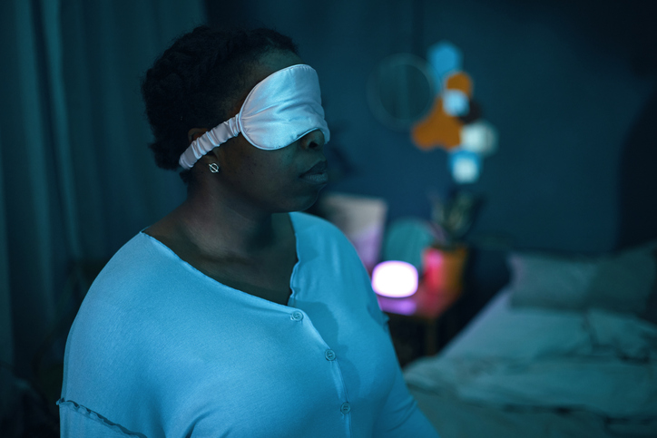 Meditating Person with Sleep Mask in Dimly Lit Room