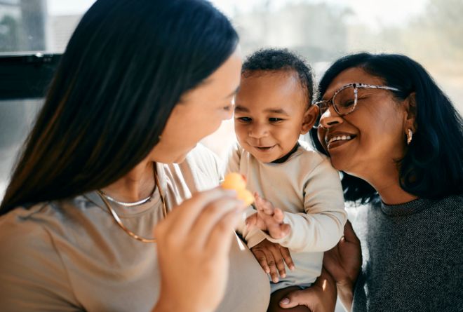 Intimate Moments With Baby Smiling Playing Joyfully Indoors With Mother and Grandmother