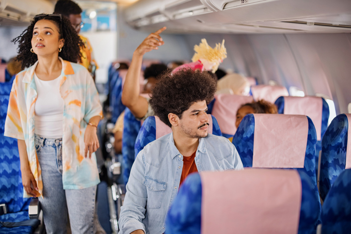 The couple finds their seats on the plane and sits down