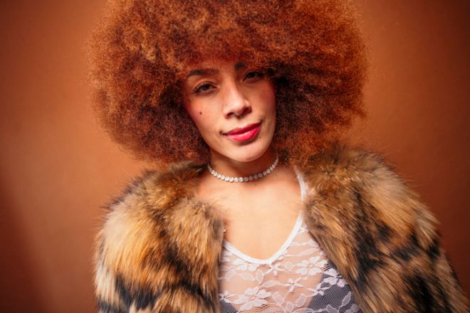 Woman posing in retro 70s fashion with afro hairstyle