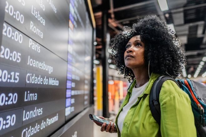 Mid adult woman looking flight monitor on a airport