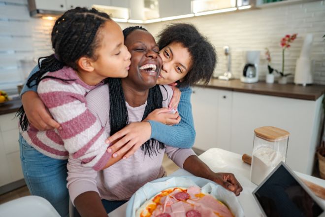 Mom and daughters preparing in pizza in the kitchen