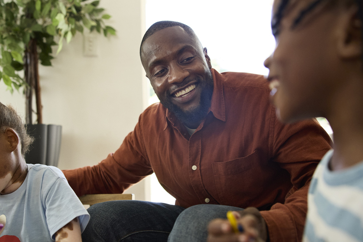 Smiling male teacher talking with boy in classroom