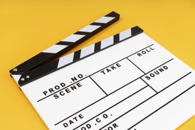 White Movie clapper board isolated on yellow background