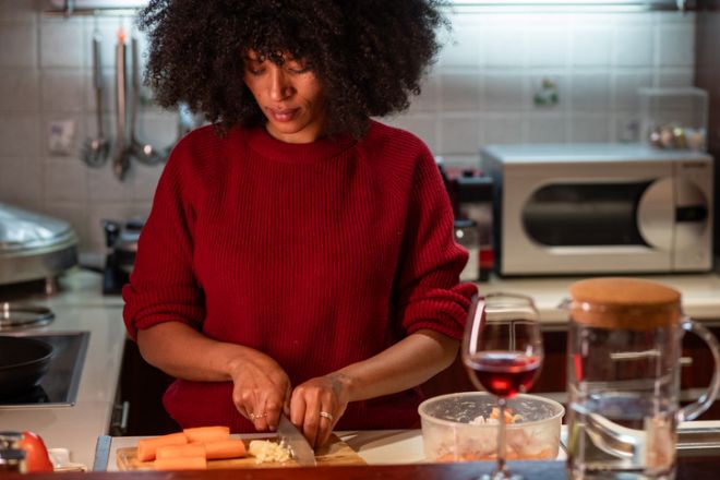 Photo showing black woman preparing healthy meal chopping vegetables in kitchen -stock photo