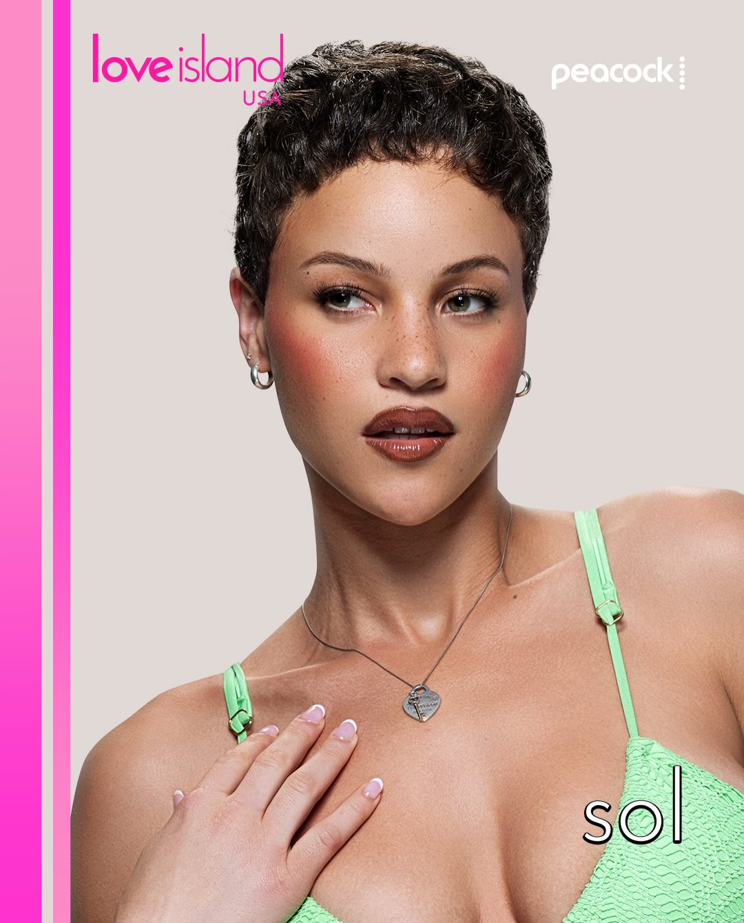 A close-up portrait of a woman with short, dark curly hair wearing a green bikini top and necklace. The "Love Island USA" logo and "Peacock" branding are visible.