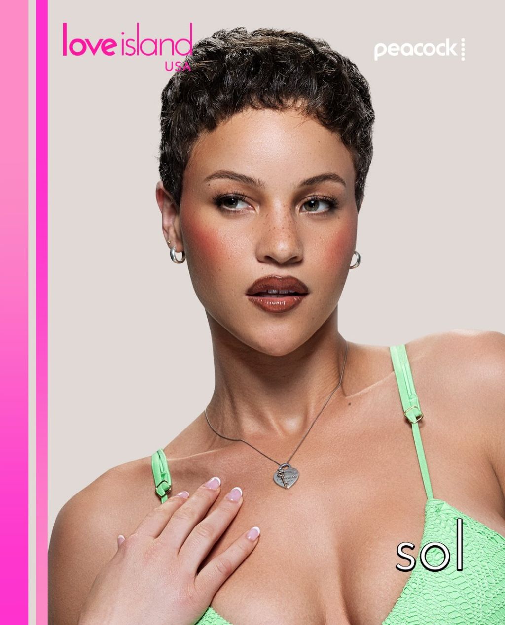 A close-up portrait of a woman with short, dark curly hair wearing a green bikini top and necklace. The "Love Island USA" logo and "Peacock" branding are visible.