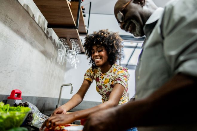 Young woman cooking with friend at home