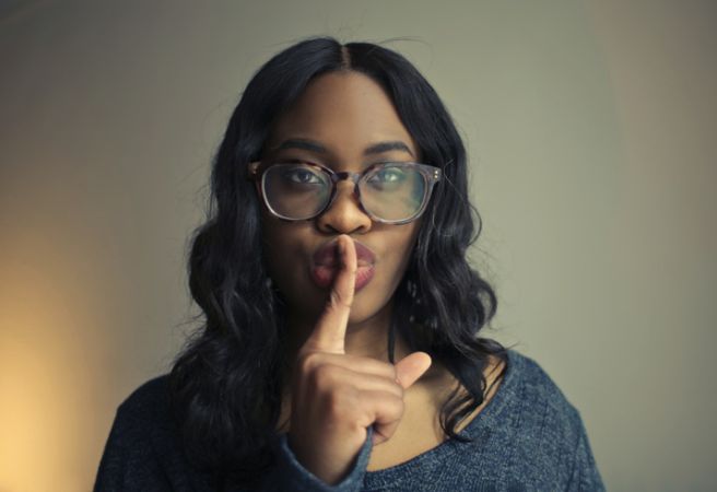 young woman gestures to be silent