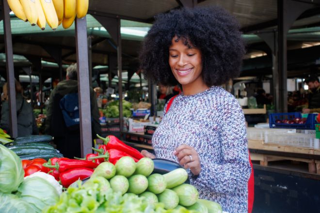 Woman selecting organic vegetables while shopping at an outdoor market