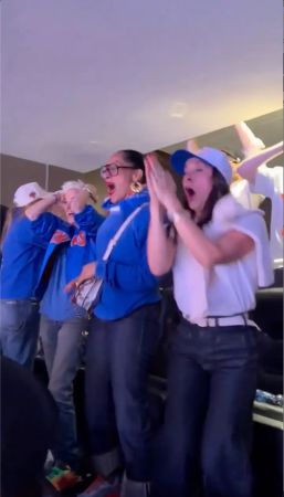 A group of people in blue uniforms cheering and celebrating enthusiastically.