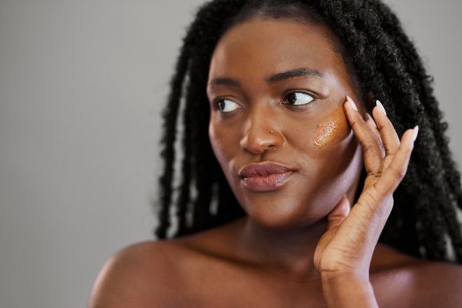 Beautiful Black Woman Applying Liquid Foundation Swatch to Face