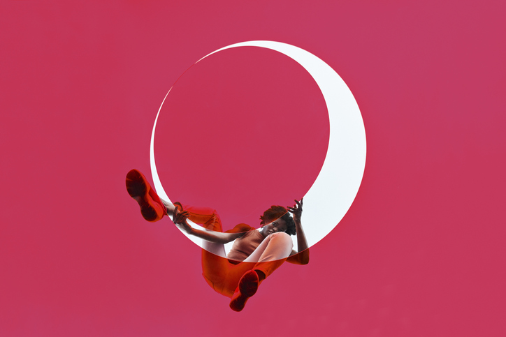 Young woman positioning pink glass on white circle