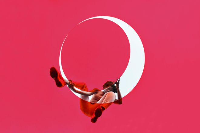 Young woman positioning pink glass on white circle