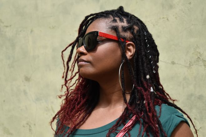 Profile of Contemporary Woman with Crimson-Tipped Dreadlocks and Large Hoop Earrings.