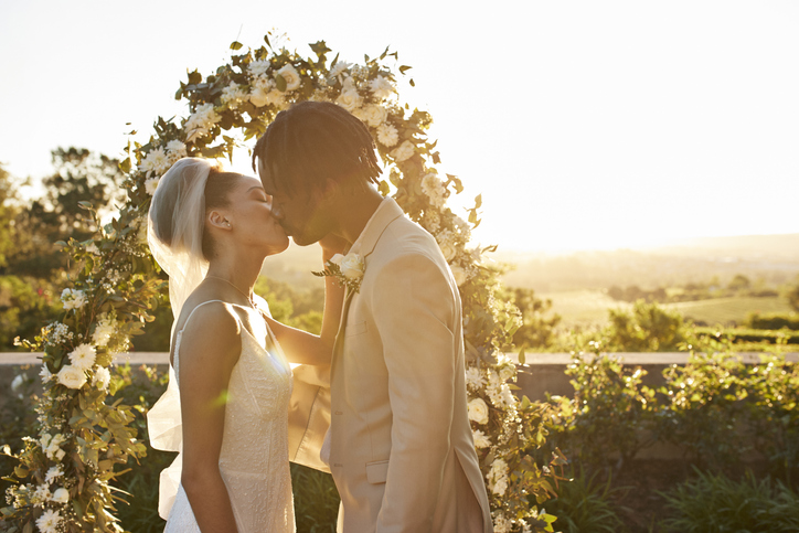 Young newlywed couple kissing at altar