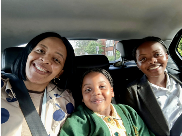 Three smiling people sitting in a car