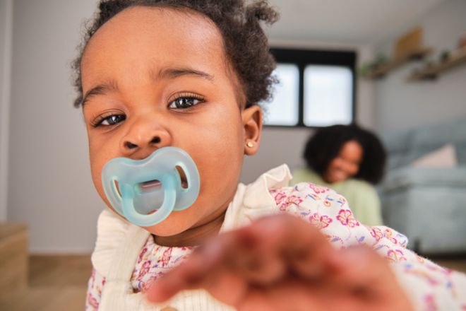 Cuban toddler baby girl trying to reach the camera at home