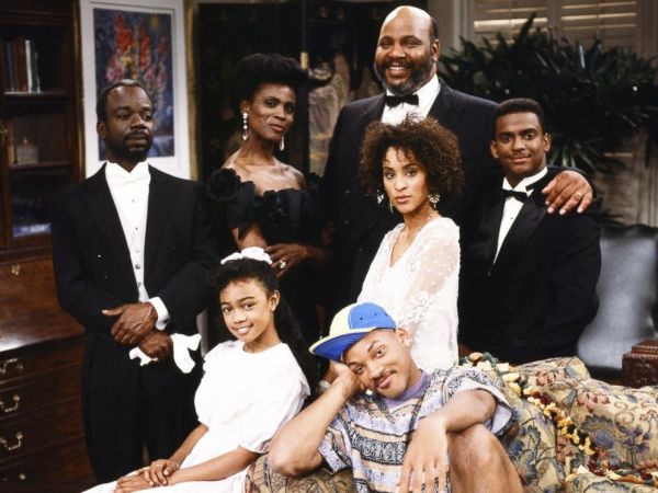 A group portrait of a smiling African American family dressed formally for a special occasion.