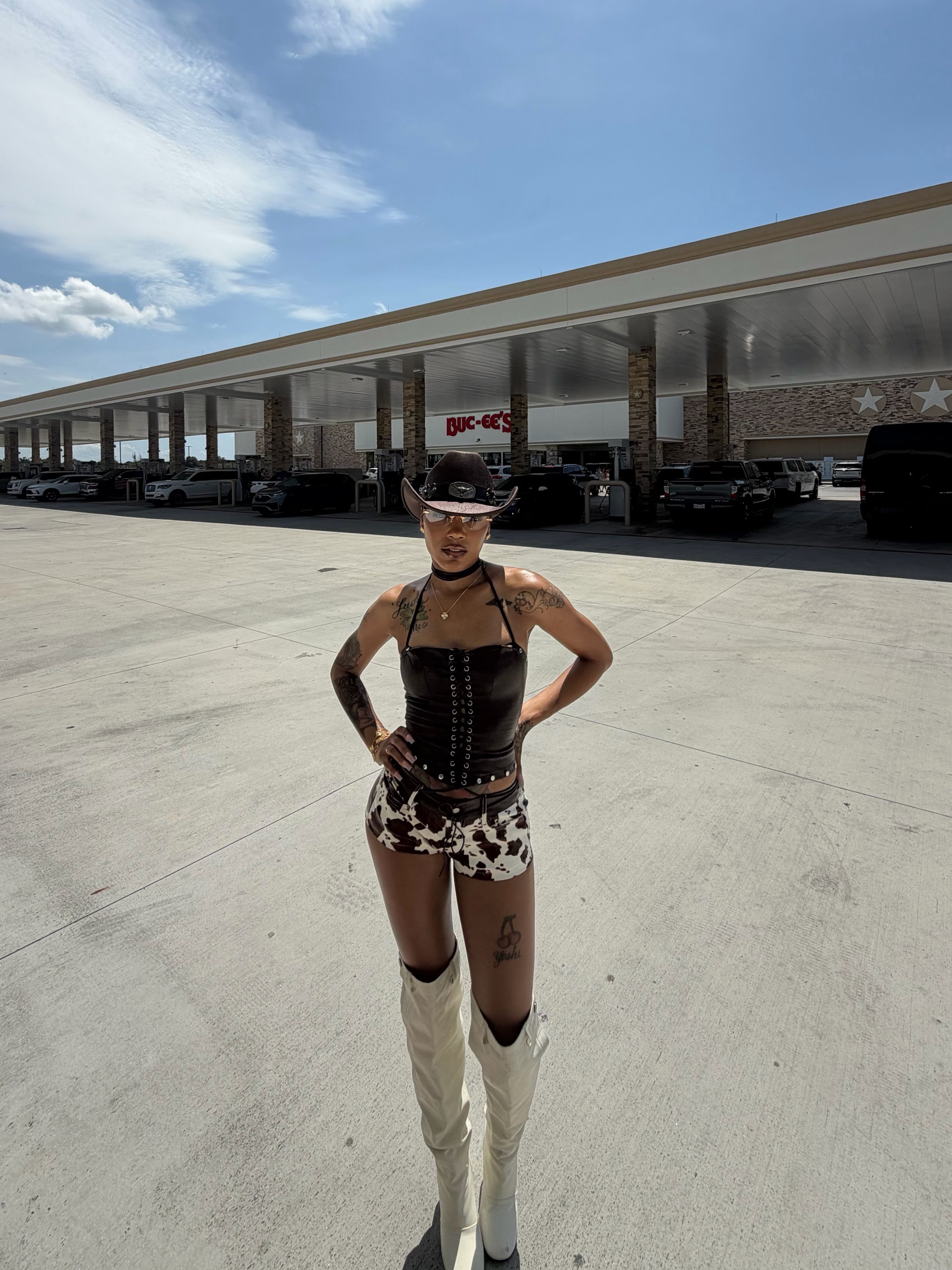 A person wearing a black crop top and patterned shorts standing in front of a large retail building with a Wic-Bee's logo.