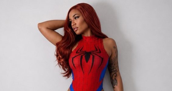 A woman wearing a red and blue Spider-Man-inspired bodysuit poses against a white background, with her arms raised and a confident expression.