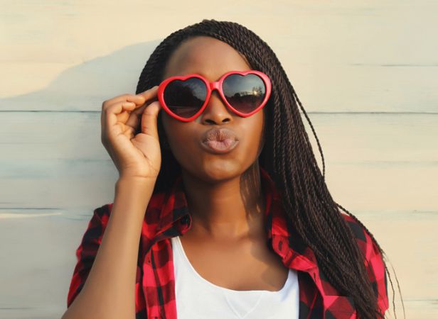 Happy young African woman in red heart shaped glasses, beautiful black girl in sunglasses