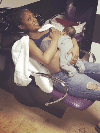 A woman sitting in a chair, holding a young child. The woman appears to be resting or relaxing.