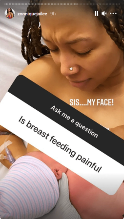 A person with braided hair and a nose piercing holding a sign that says "Is breast feeding painful?