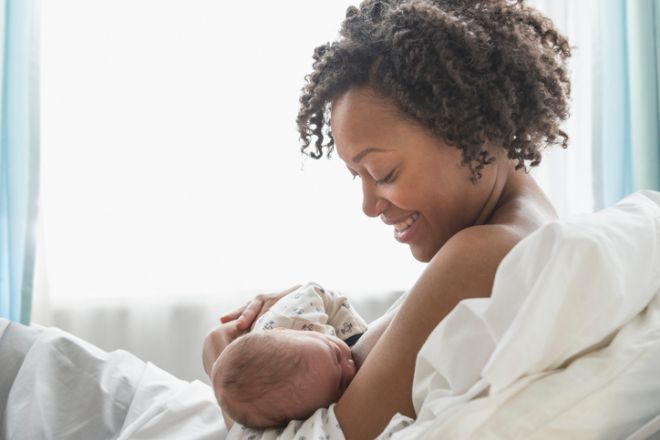 Mixed race mother nursing newborn baby