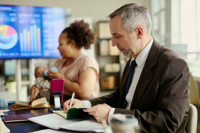 Black Mother Caring for Baby in Office during Business Meeting